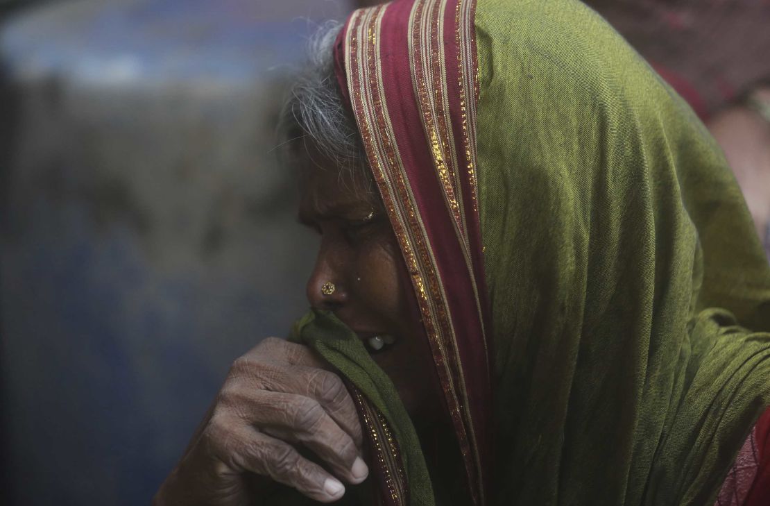 A woman mourns relatives who died in the heavy rainfall. 