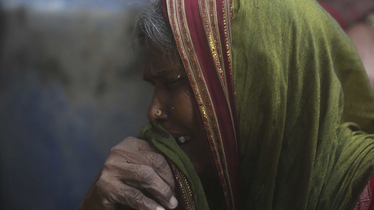 A woman mourns relatives who died in the heavy rainfall. 