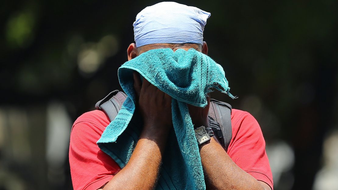An Indian man uses a towel to wipe the sweat on his face on a hot and humid summer day in Hyderabad, India, on June 3, 2019.