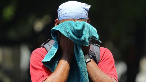 An Indian man uses a towel to wipe the sweat on his face on a hot and humid summer day in Hyderabad, India, on June 3, 2019.  