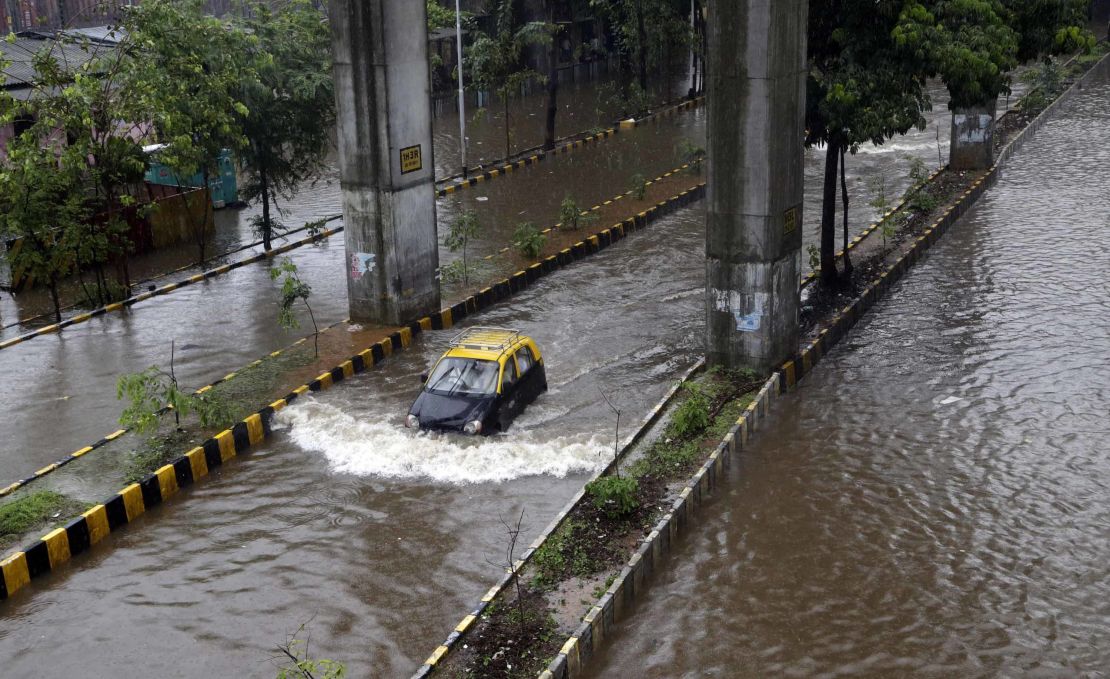 A car moves through a waterlogged street following heavy rains in Mumbai, India, on July 2, 2019. 