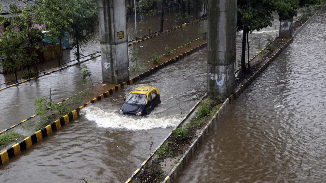 A car moves through a waterlogged street following heavy rains in Mumbai, India, on July 2, 2019.