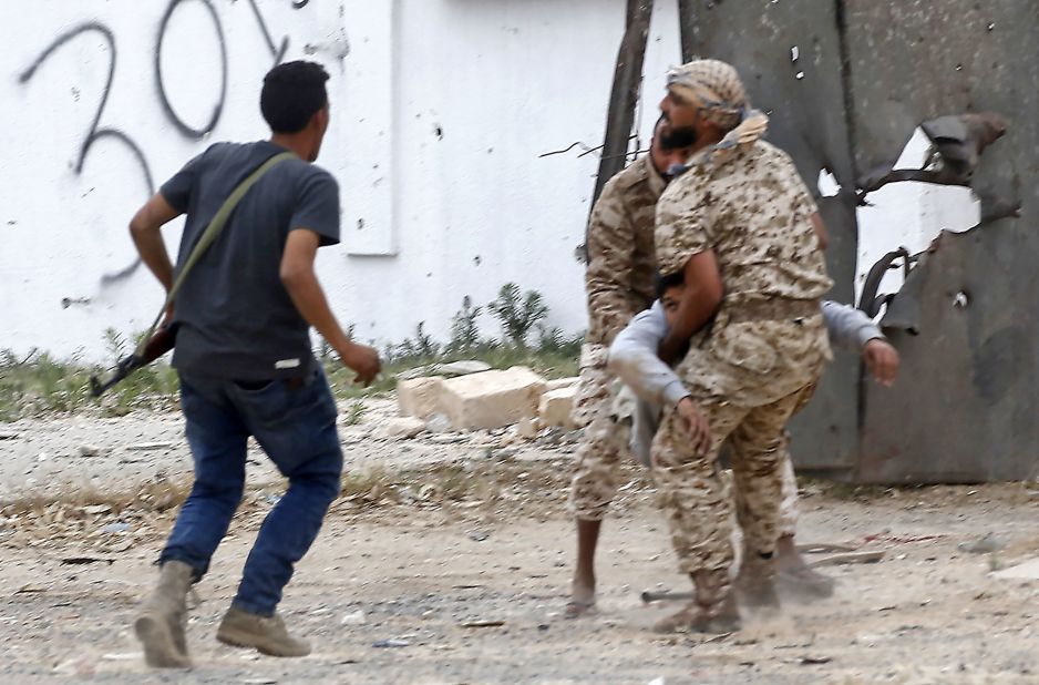 Government of National Accord fighters carry a wounded comrade during a battle on May 21 in the Salah al-Din area, south of Tripoli.
