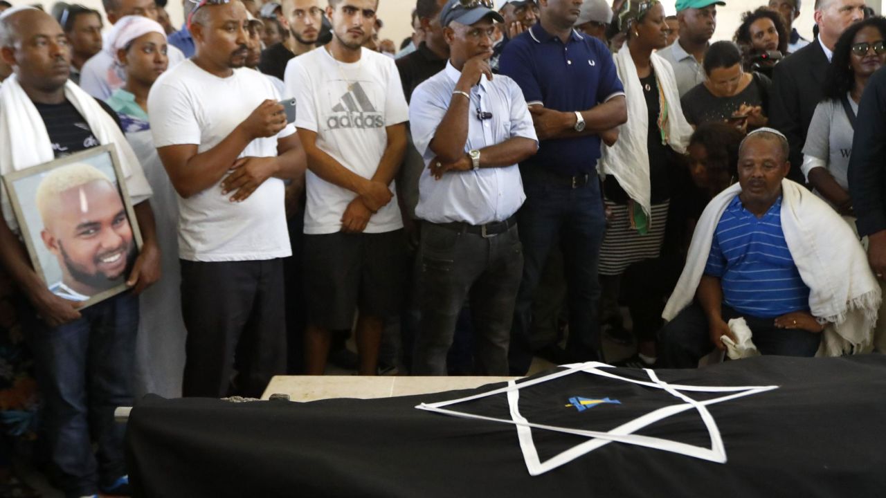 Worka (R), the father of Solomon Teka, mourns over his body during his funeral.