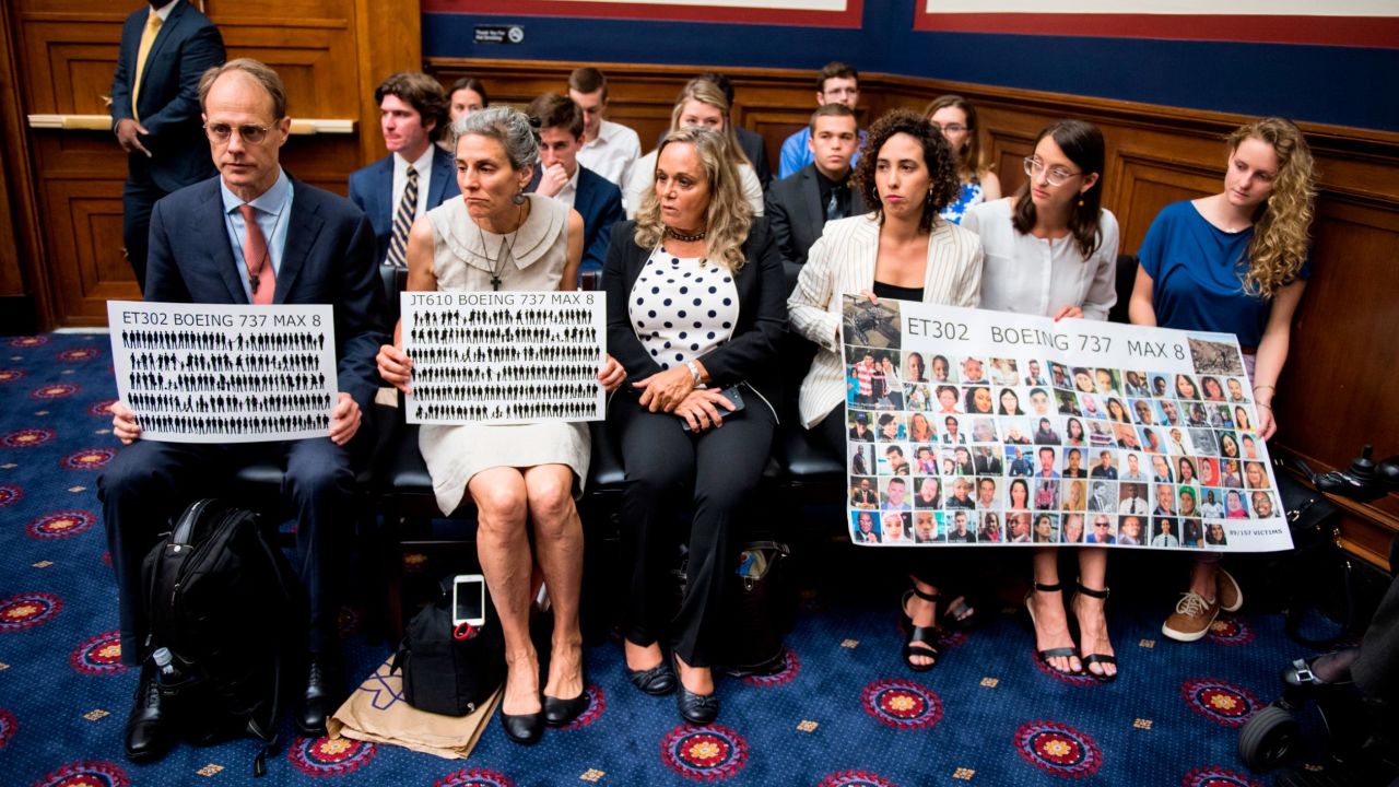 Families of those killed in the 737 Max crashes hold up signs depicting their loved ones during a Congressional meeting last month. 