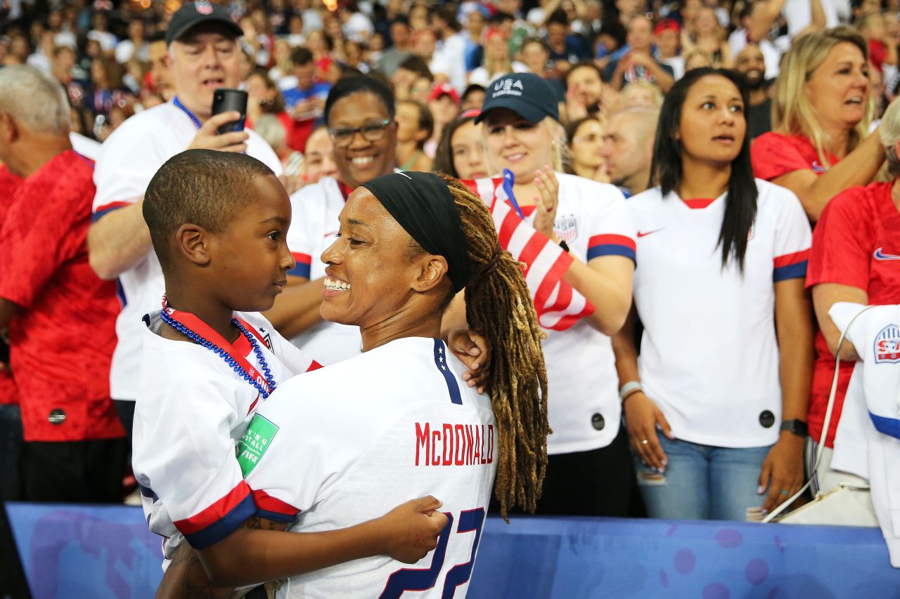 US forward Jessica McDonald holds her son, Jeremiah, after the France win.
