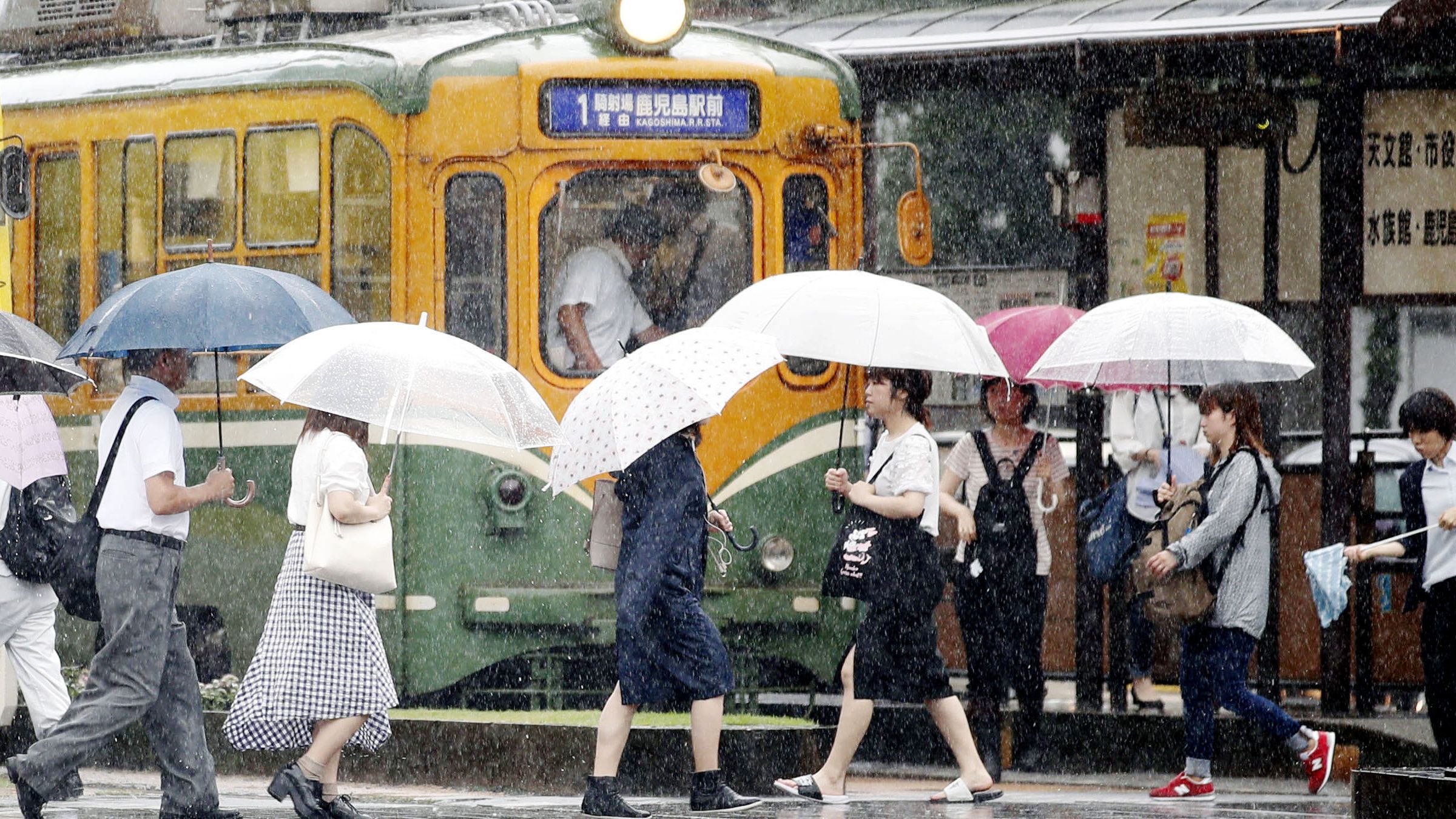 People walk in the rain in Kagoshima, southwest Japan, on July 2, 2019. 