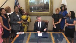 California Gov. Gavin Newsom, middle, signs State Bill, SB-188 Discrimination: hairstyles by state Sen. Holly Mitchell of Los Angeles, third from left, that bans workplace and school discrimination against black people for wearing natural hairstyles, including locks and braids. Newsom signed the law, the first of its kind by any state, at the Capitol in Sacramento on Wednesday, July 3, 2019. Federal courts, though, have regularly ruled that hairstyles do not count as an "immutable" characteristic of race, meaning a trait that can't be changed, and therefore don't get protection under racial discrimination laws. (AP Photo/Kathleen Ronayne)