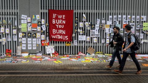 People walk past signs and posters outside the government headquarters in Hong Kong on July 2.