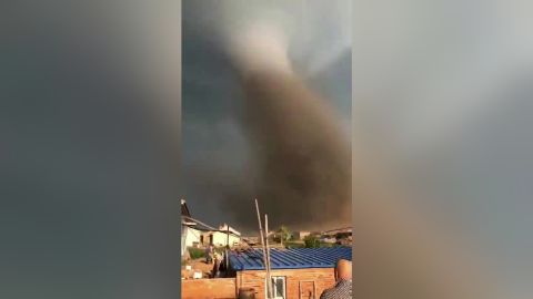 A tornado sweeps through residential buildings and streets in Kaiyuan city.
