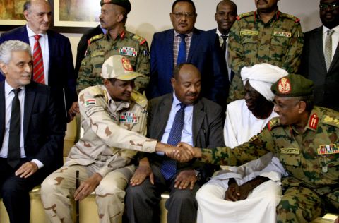 African Union envoy to Sudan Mohamed al-Hacen Lebatt, second from left, shakes hands with an army general following a press conference announcing an agreement was reached. Under the terms, the military council will be in charge of the country's leadership for the first 21 months. A civilian administration will rule the council during the following 18 months.