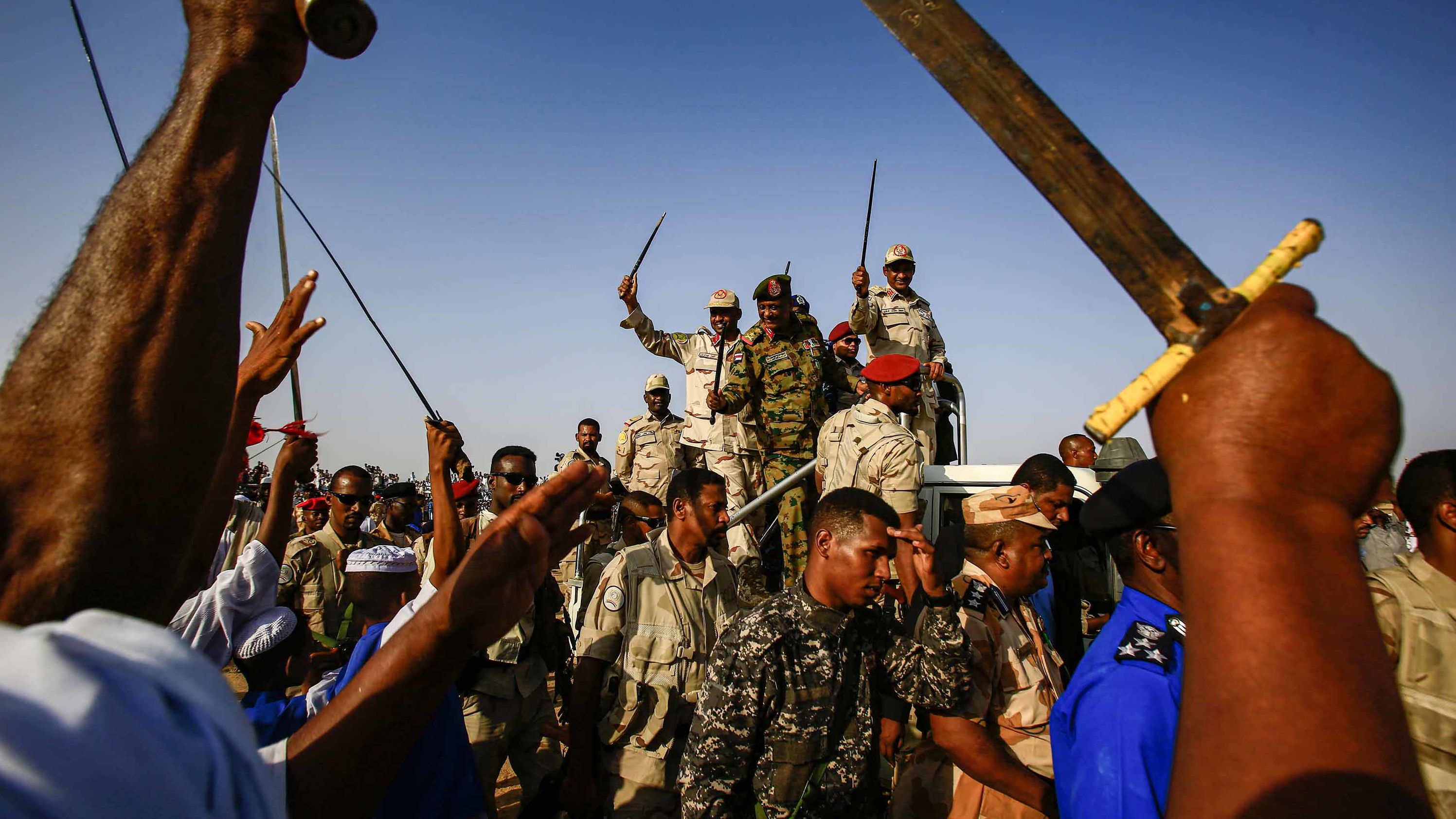 Mohamed Hamdan Dagalo, deputy head of Sudan's ruling Transitional Military Council (TMC) and commander of the Rapid Support Forces (RSF) paramilitaries, center right, waves a baton as he rides through supporters in Qarri, north of Khartoum, on June 15.