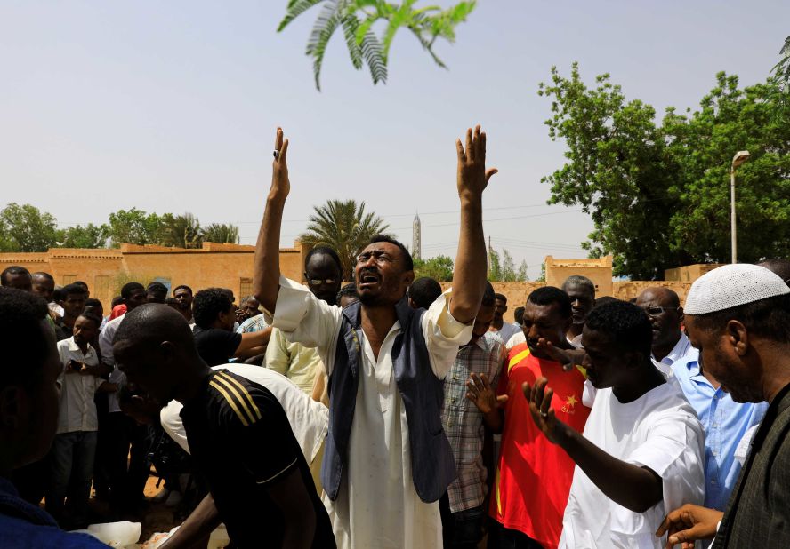 Relatives of three Sudanese men who were found dead with bullet wounds mourn near their bodies in the city of Omdurman on July 1.