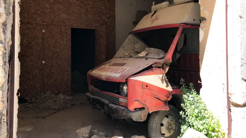 <strong>Failed rescue:</strong> Reminders of the tragedy are still visible. Underneath a fallen roof lies a crushed 1960s ambulance, emblazoned with a red cross. Its wheels are turned to the right -- it was exiting from the garage when the ground shook. It never made it out to rescue those in need.