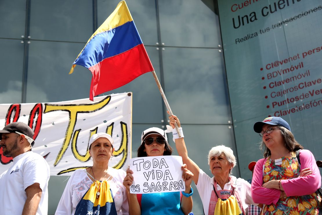 Venezuelans wave flags and hold signs at a demonstration called by opposition leader Juan Guaidó. The motto of the protest is "No more torture."