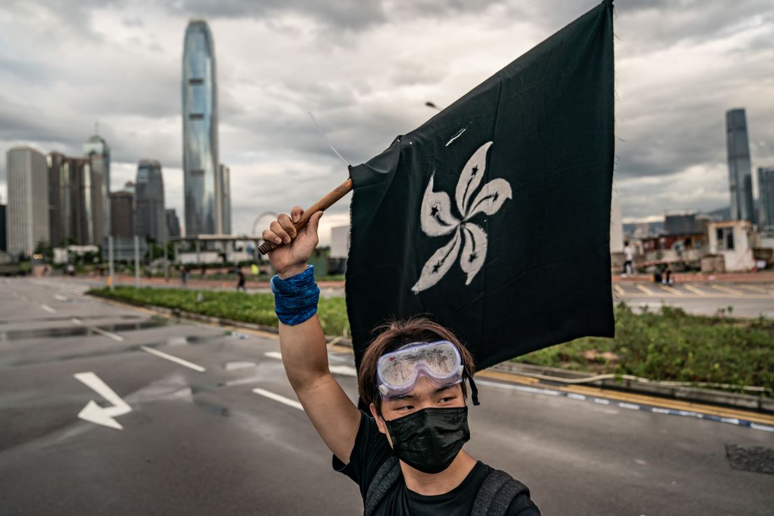 A protester holds aloft a black reinterpretation of the Hong Kong flag.