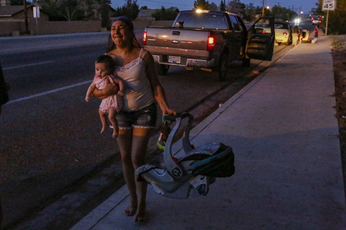 Dawn Inscore runs out of her apartment with her child after a 7.1 earthquake hit Ridgecrest.