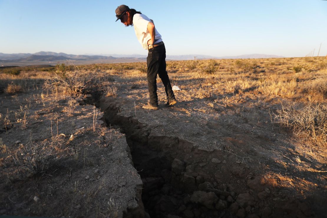 A man inspects a crack in the earth after a 6.4-magnitude earthquake struck near Ridgecrest on July 4, 2019.