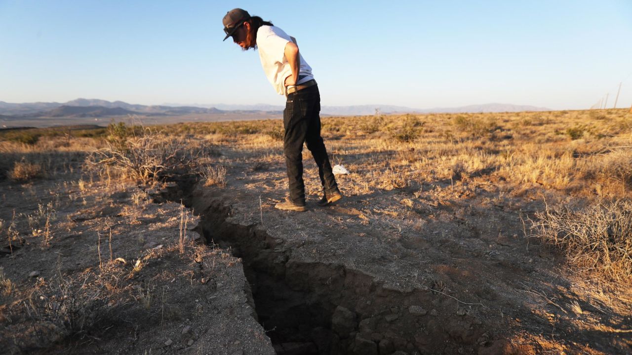 A resident inspects a crack in the earth after a 6.4 magnitude earthquake struck on July 4 near Ridgecrest, California. 