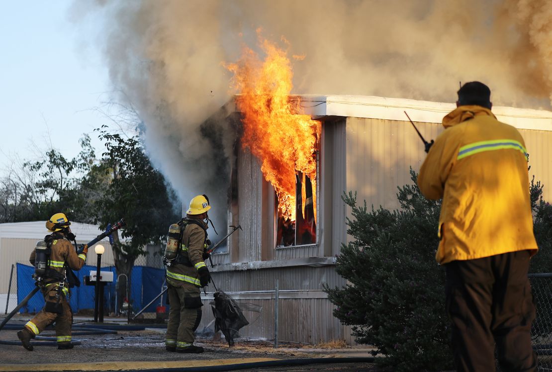 Firefighters battle a house fire on Saturday, July 6, 2019 in Ridgecrest, California, the morning after a 7.1 magnitude earthquake struck the area.