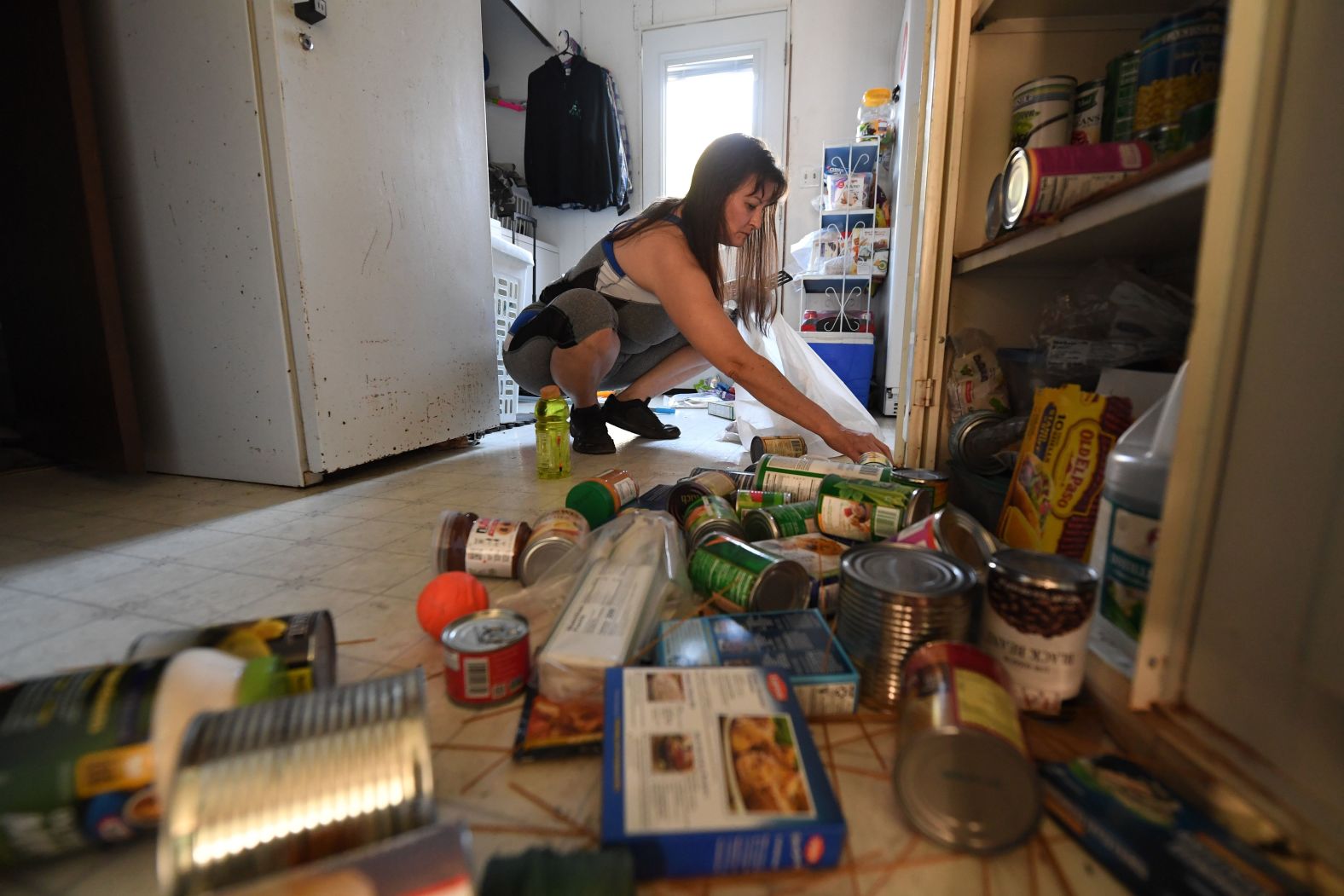 Tammy Sears cleans up her kitchen on July 6 after a magnitude 7.1 earthquake dumped food items on the floor at her mobile home in Ridgecrest.