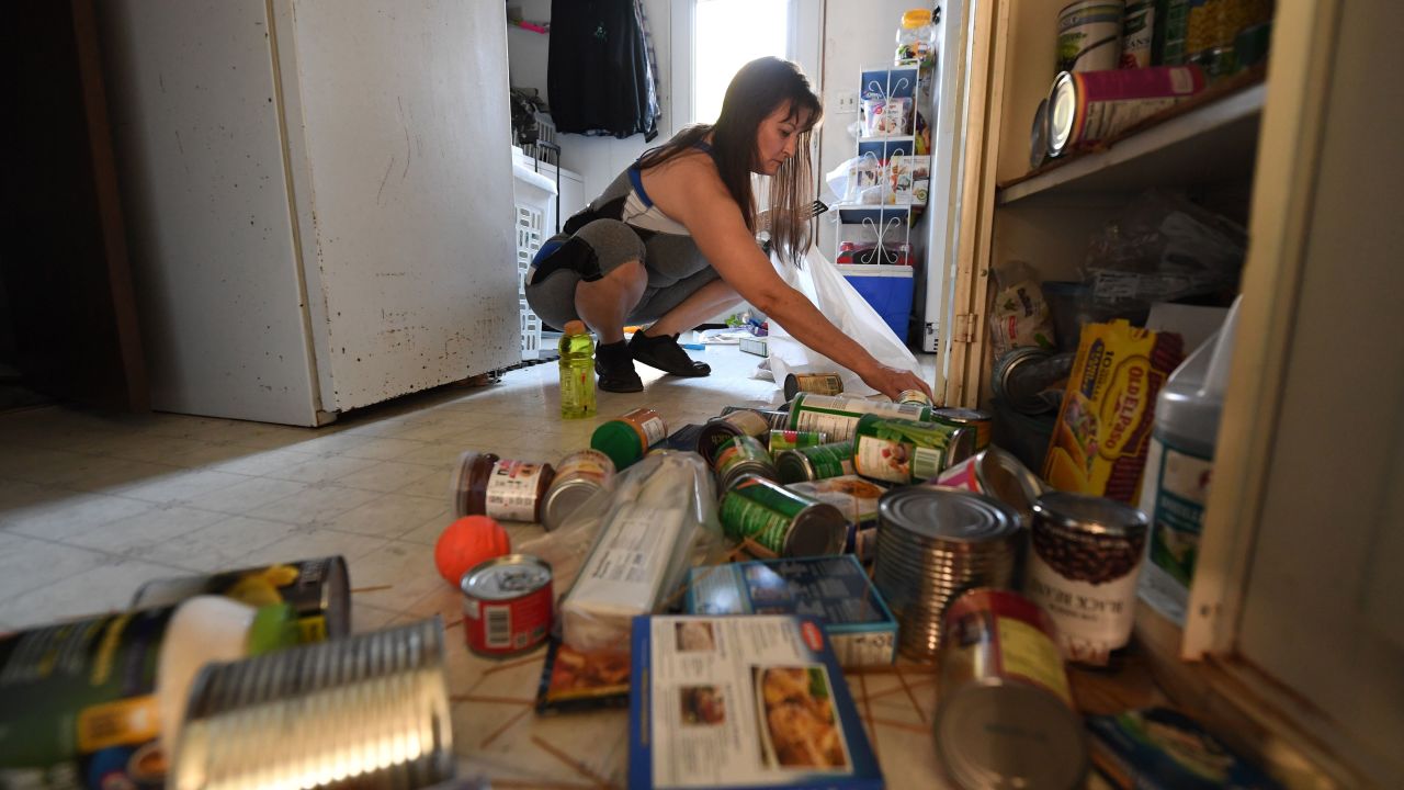 Tammy Sears cleans up her kitchen on July 6, 2019, after a magnitude 7.1 earthquake dumped food items on the floor  of her mobile home in Ridgecrest, California.