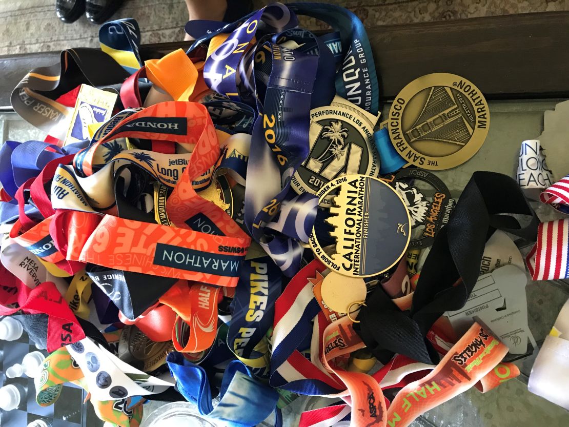 A pile of Meza's racing medals rests on a coffee table at home.