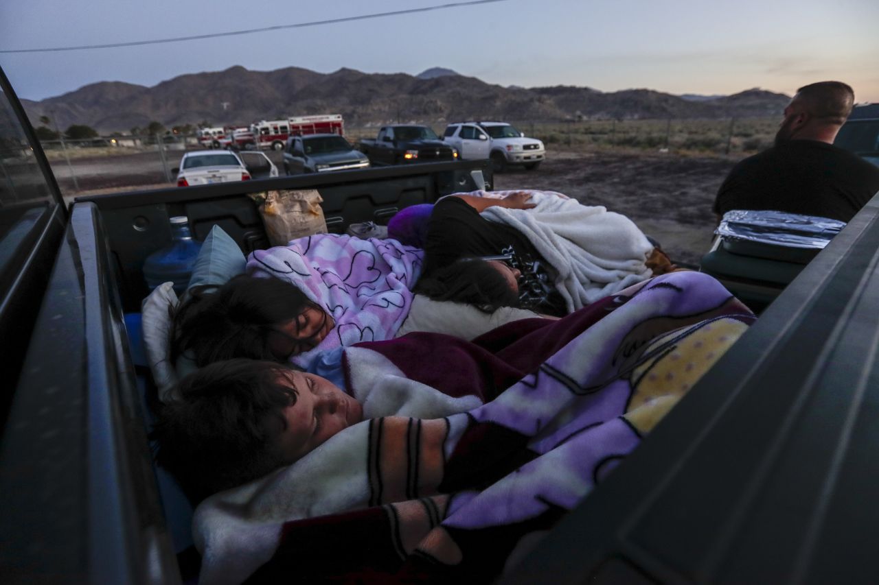 The Horta family, forced from their home as a result of the earthquake, sleeps in the bed of their pickup truck at a fire station parking lot on July 6 in Trona, California.