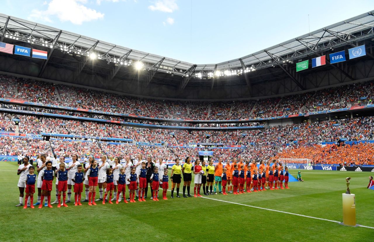 The teams stand for their national anthems before the match.