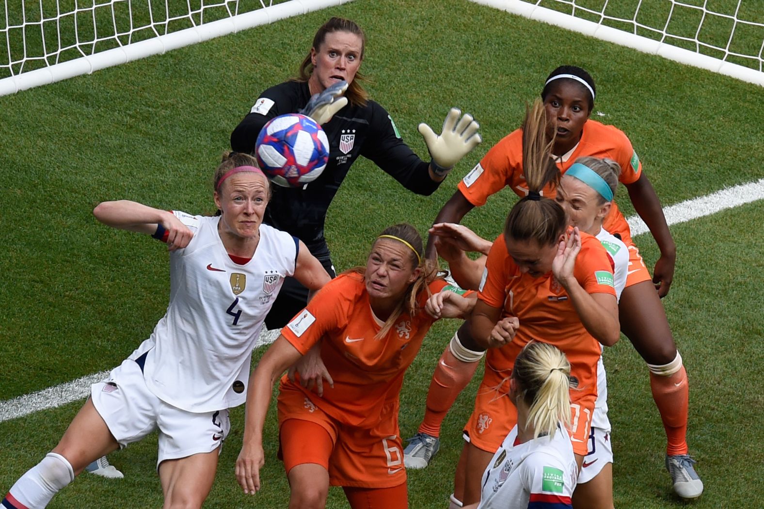 Players eye a ball in the US penalty box.