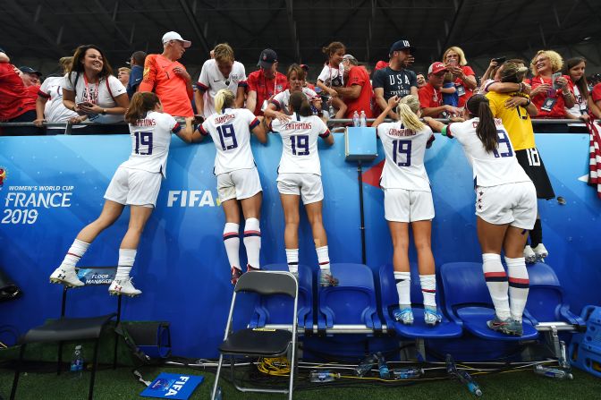 US players, wearing new "Champions 19" jerseys, celebrate with family and friends in the crowd.