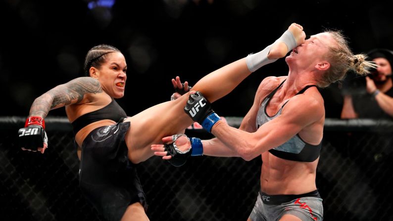 Amanda Nunes, left, kicks Holly Holm in the head, knocking her to the mat during the first round of their bantamweight title fight at UFC 239 in Las Vegas, Nevada, on Saturday, June 6.