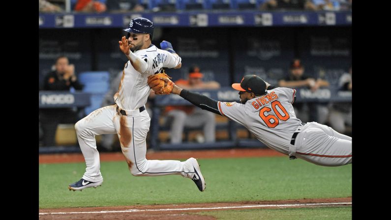 Baltimore Orioles pitcher Mychal Givens, right, dives to tag out Tampa Bay Rays' Kevin Kiermaier during the eighth inning of a baseball game in St. Petersburg, Florida, on Wednesday, July 3.
