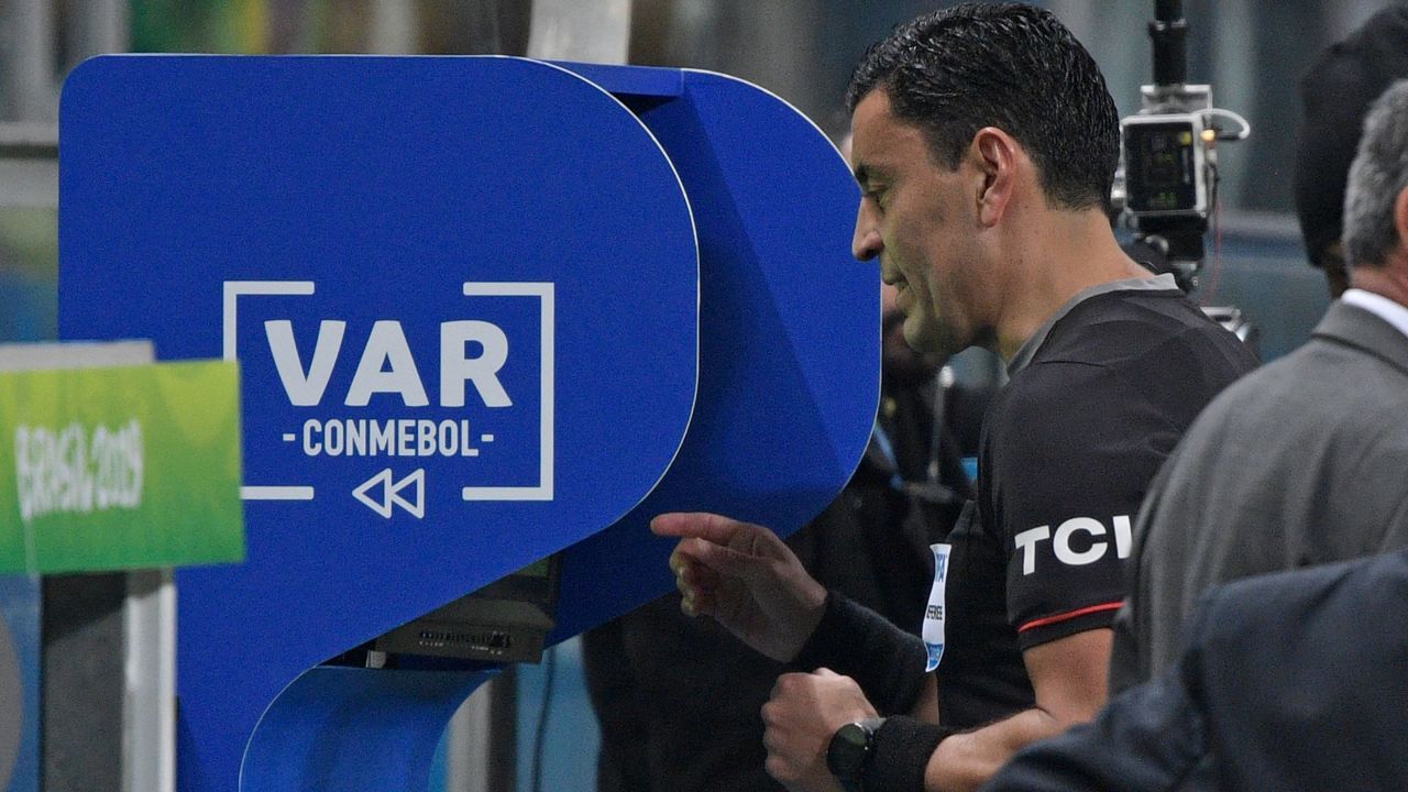 Chilean referee Roberto Tobar checks the VAR to show the red card to Paraguay's Fabian Balbuena after a foul on Brazil's Roberto Firmino on the border of the area during their Copa America football tournament quarter-final match at the Gremio Arena in Porto Alegre, Brazil, on June 27, 2019. (Photo by Juan MABROMATA / AFP)        (Photo credit should read JUAN MABROMATA/AFP/Getty Images)