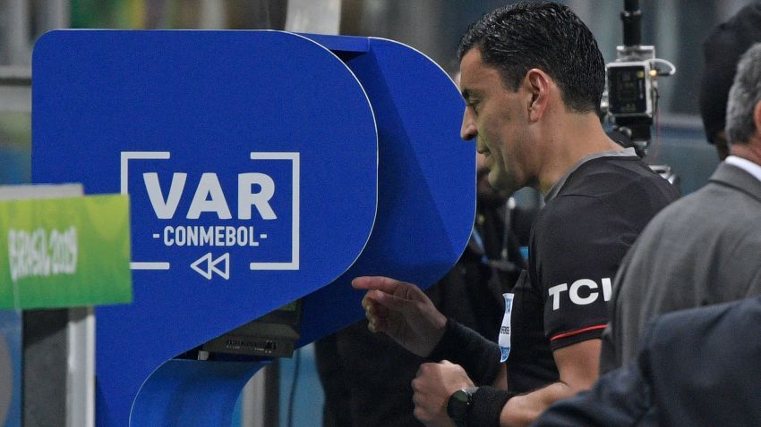 Chilean referee Roberto Tobar checks the VAR to show the red card to Paraguay's Fabian Balbuena after a foul on Brazil's Roberto Firmino on the border of the area during their Copa America football tournament quarter-final match at the Gremio Arena in Porto Alegre, Brazil, on June 27, 2019. (Photo by Juan MABROMATA / AFP)        (Photo credit should read JUAN MABROMATA/AFP/Getty Images)