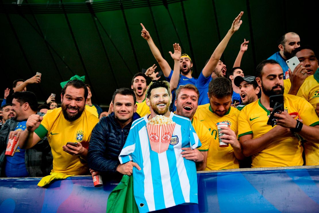 Fans of Brazil hold an image of Argentine footballer Lionel Messi eating popcorn as they celebrate winning the 2019 Copa America.
