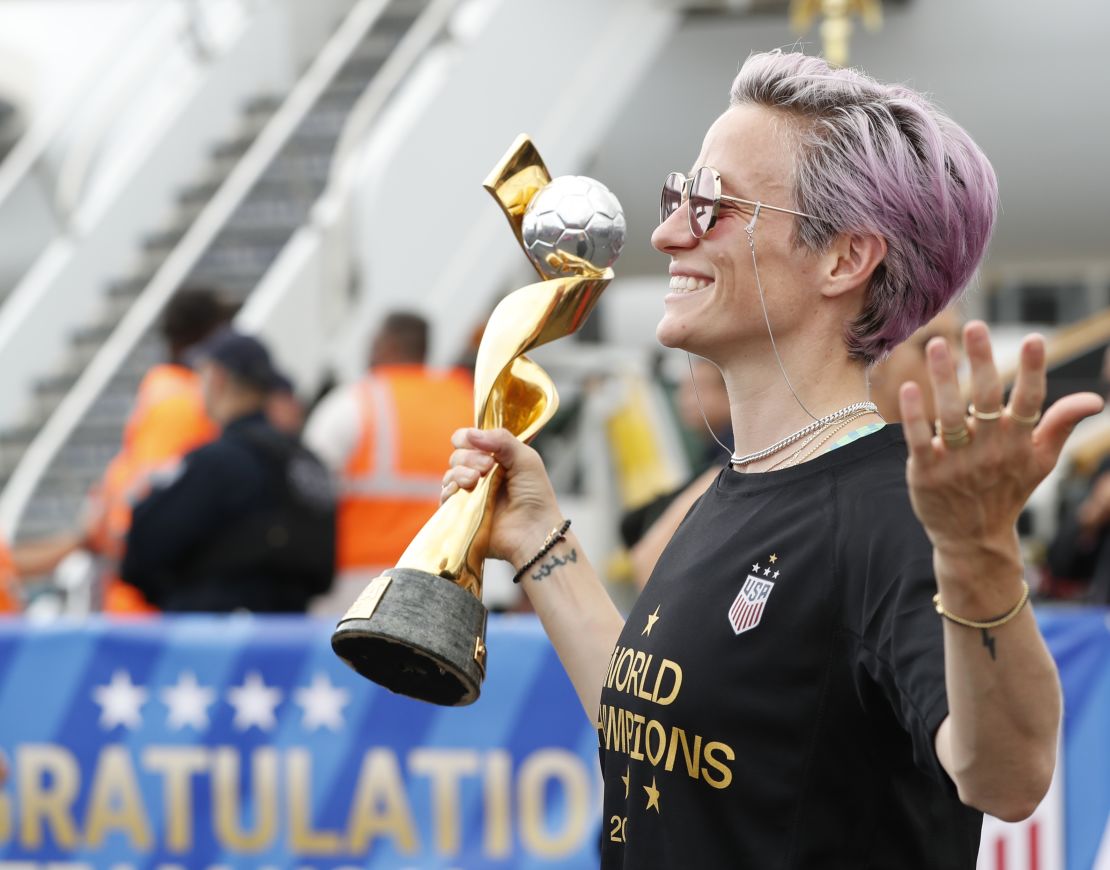 United States women's soccer team member Megan Rapinoe holds the Women's World Cup trophy as she poses for the media after arriving with the rest of the team at Newark Liberty International Airport, Monday, July 8, 2019, in Newark, N.J. (AP Photo/Kathy Willens)