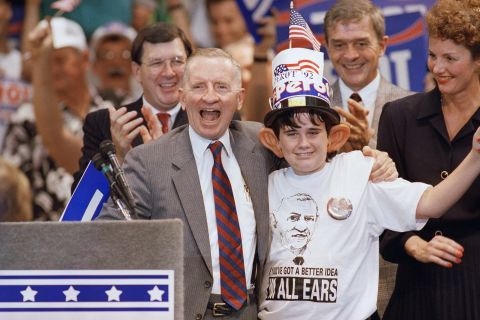Perot laughs with 12-year-old supporter Kevin Grace following a campaign rally in Tampa, Florida, in October 1992. Perot and his supporters embraced his large ears, and Perot even joked about them in a debate. When talking about the gas tax, Perot broke out the one-liner: "If there's a fairer way, I'm all ears!"