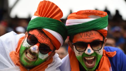 Indian supporters with faces painted in the national colours pose for a photograph.