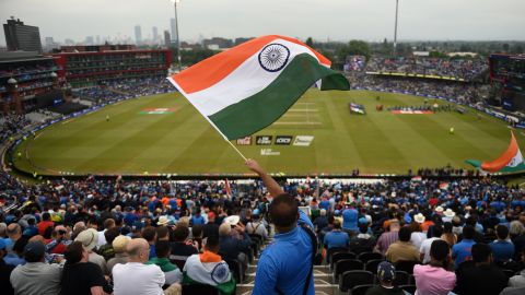 An Indian supporter waves the national flag high up in the stands as the teams come out.