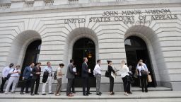 People wait in line to enter the 5th Circuit Court of Appeals to sit in overflow rooms to hear arguments in New Orleans, Tuesday, July 9, 2019. (AP Photo/Gerald Herbert)
