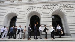 People wait in line to enter the 5th Circuit Court of Appeals to sit in overflow rooms to hear arguments in New Orleans, Tuesday, July 9, 2019. The appeals court will hear arguments today on whether Congress effectively invalidated former President Barack Obama's entire signature health care law when it zeroed out the tax imposed on those who chose not to buy insurance. A Texas judge in December ruled it was invalid, setting off an appeal by states who support the law.  (AP Photo/Gerald Herbert)