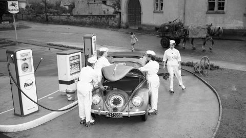 Female gas station employees on rollerskates attend to a Volkswagen in Deidesheim, Germany, in 1954. The original Beetle's engine was in the back, leaving the area under the hood for cargo and the spare tire.