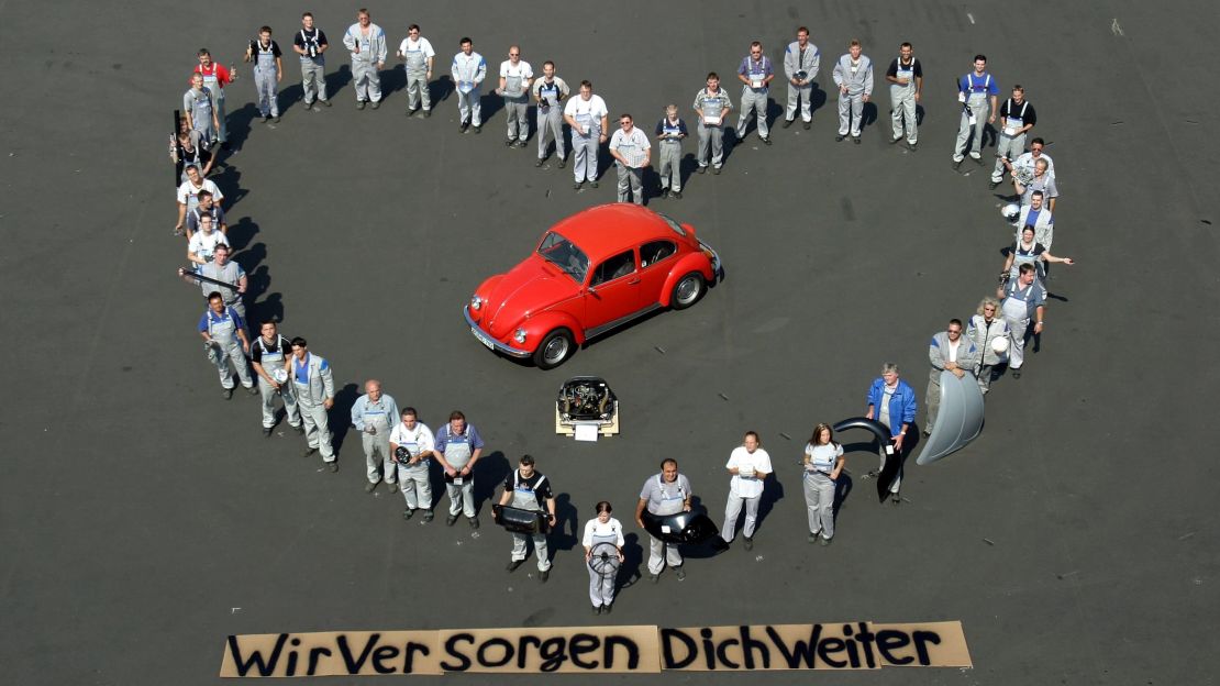 Volkswagen employees in Germany hold spare parts as they pose in the shape of a heart around an old VW Beetle. The company promises to supply parts for the old Beetle over the next 15 years. The banner at the bottom reads 'we will continue to attend to you.'