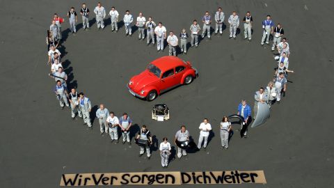 Volkswagen employees in Germany hold spare parts as they pose in the shape of a heart around an old VW Beetle. The company promises to supply parts for the old Beetle over the next 15 years. The banner at the bottom reads 'we will continue to attend to you.' 