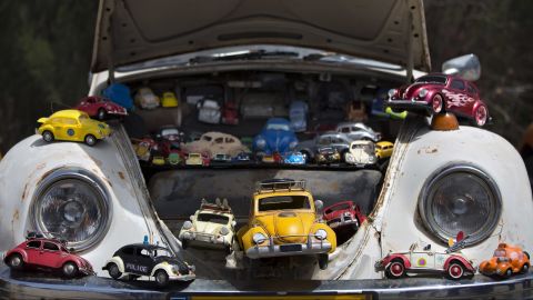 With its playful shape, the Beetle has inspired endless numbers of miniature toy versions. Here, some of them are displayed inside the front trunk, or "frunk," of an old Beetle. 