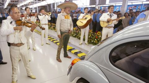 Even after the New Beetle was introduced, the old rear-engined Beetles continued to be made for some markets. The last one was finally produced in 2003 in a factory in Mexico. Here, musicians serenade the last old-style Beetle as it leaves the assembly line.