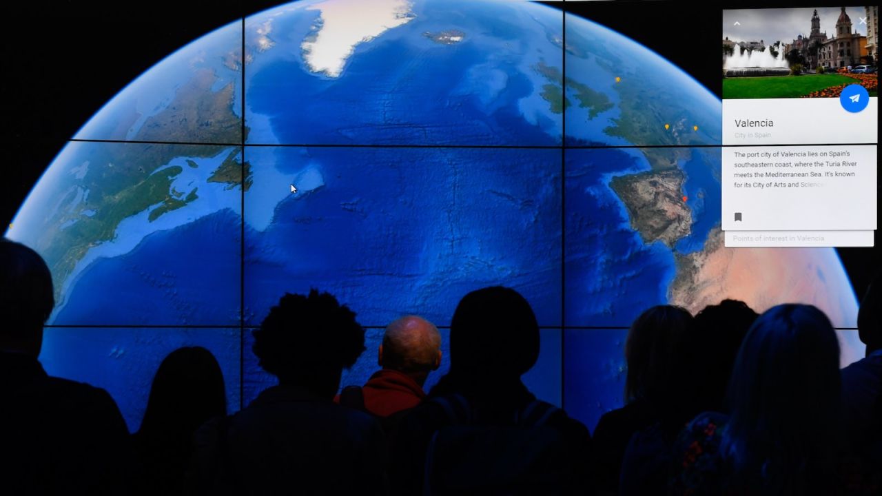 People look at a Google Earth map on a screen as Google Earth unveils the revamped version of the application April 18, 2017 at a event at New York's Whitney Museum of Art.