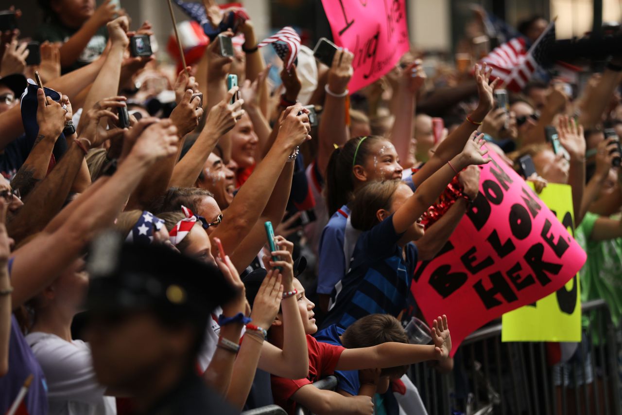 Fans cheer as members of the US Women's National Soccer Team travel through the ticker tape parade.