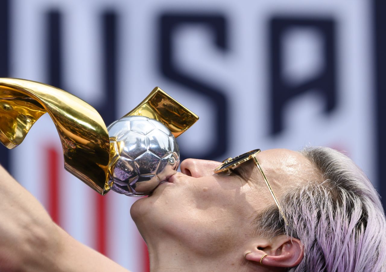 Rapinoe kisses the trophy in front of the City Hall after the ticker tape parade.